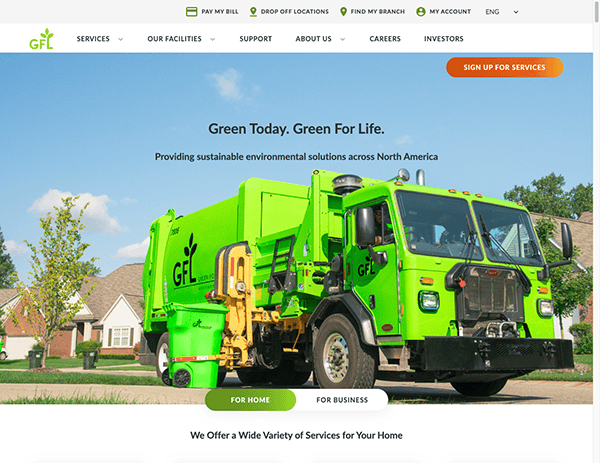 A bright green GFL environmental services truck is parked in a suburban neighborhood. The vehicle features the company's logo and appears in front of a promotional banner on their website.