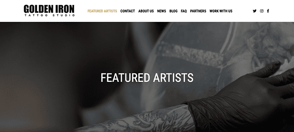 Black and white photo of a tattooed artist's hands working on a client, with the text "featured artists" prominently displayed on a tattoo studio website.