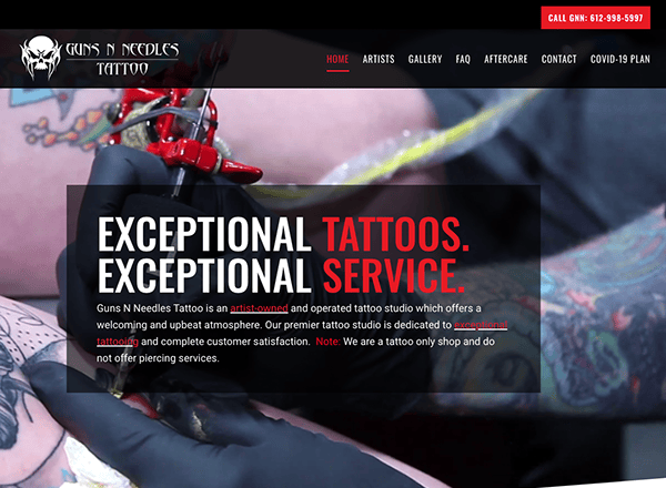 A tattoo artist at work in a tattoo studio, viewed through the website interface of guns n needles tattoo with navigation tabs and contact information.