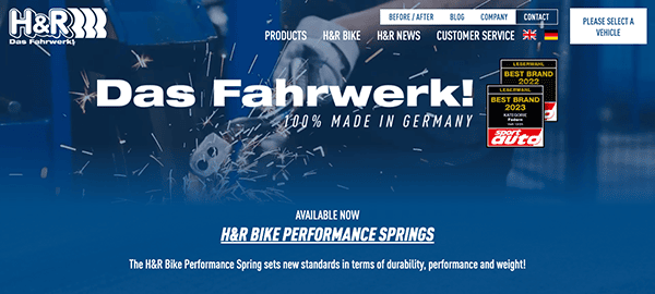 Website homepage of h&r suspension systems featuring "das fahrwerk!" slogan, advertising bike performance springs with a predominantly blue and black color scheme.