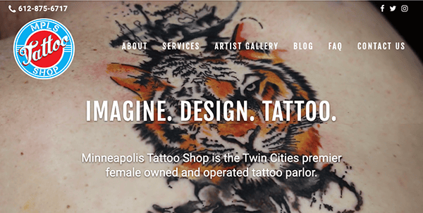 Website homepage of minneapolis tattoo shop featuring a close-up image of a tiger tattoo on human skin with navigation links and contact information.