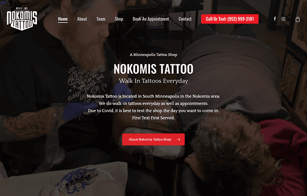 A tattoo artist focuses on tattooing a client's arm in a tattoo studio, with promotional text and contact information visible on the screen.