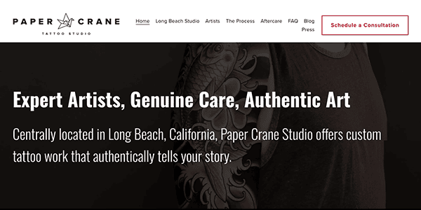 Website header for paper crane tattoo studio featuring navigation menu, studio slogan "expert artists, genuine care, authentic art," and a "schedule a consultation" button.