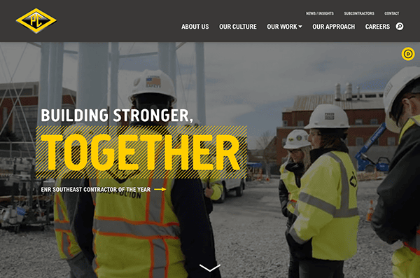 Construction workers in hard hats engaging in a discussion at a construction site with a banner reading "building stronger, together" across the image.
