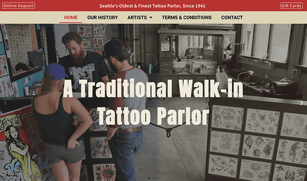 A tattoo artist discusses options with a couple in a traditional tattoo parlor decorated with wall art and vintage furniture.