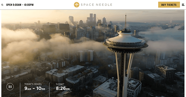Aerial view of seattle's space needle at sunrise with low clouds covering the cityscape.