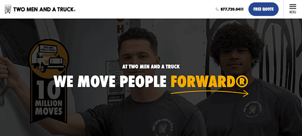 Two men in grey shirts standing in front of a banner that reads, "At Two Men and a Truck® We Move People Forward®" with a "10 Million Moves" emblem on the left side.