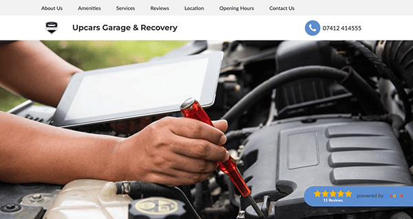 A person in a garage using a tablet and screwdriver to work on a car engine. The website header displays business information, including services, location, contact details, and customer reviews.