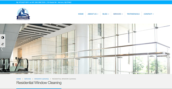 Screenshot of a webpage for All County Window Cleaning. The page shows a modern building's interior and has navigation links for Home, About Us, Blog, Services, Testimonials, and Contact.