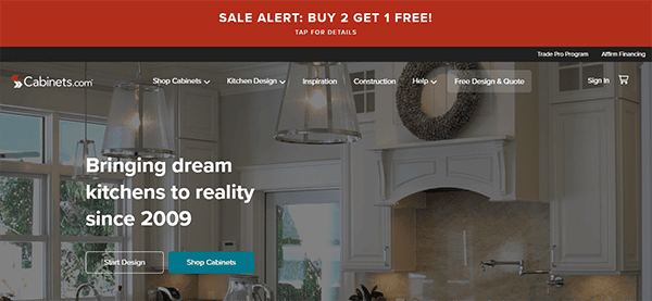 Screenshot of Cabinets.com homepage featuring a kitchen design, with a red banner at the top reading "SALE ALERT: BUY 2 GET 1 FREE!". Options include Shop Cabinets, Design Services, and Financing.