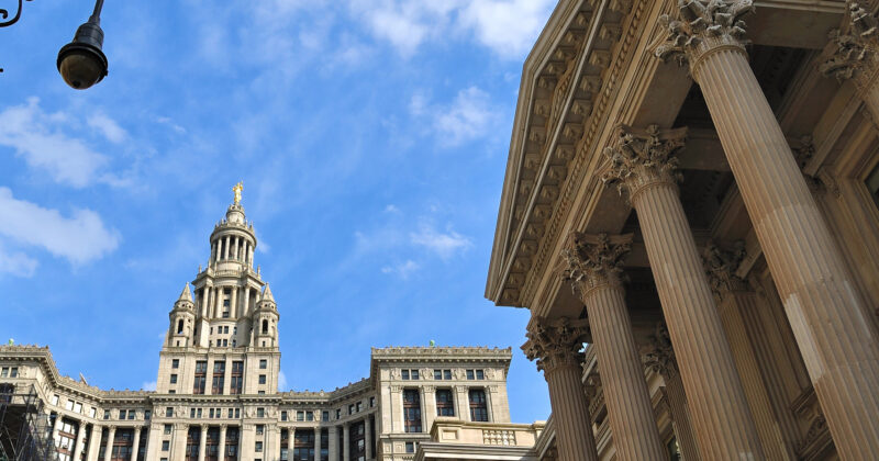 A view of historic buildings with detailed architectural features and columns against a blue sky, reminiscent of the elegance found in top-tier municipal website designs.