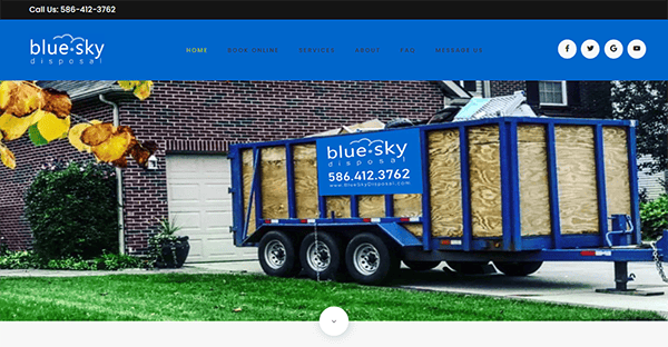 A blue waste disposal dumpster with "Blue Sky Disposal" and a phone number is parked on a residential driveway next to a brick house and a green lawn.