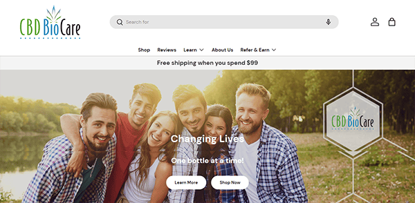 Group of five people outdoors smiling and posing for a photo, with a "CBD BioCare" website banner and text offering free shipping on orders over $99. .