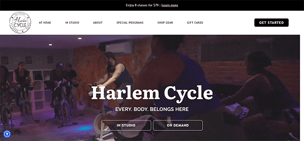 A group of people participate in a spin class at Harlem Cycle. The text reads "Harlem Cycle: Every. Body. Belongs Here." Options for 'In Studio' and 'On Demand' are displayed.