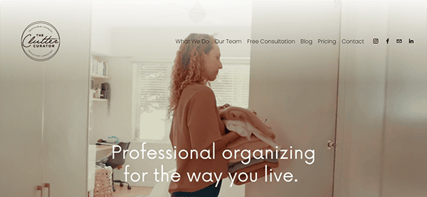 A woman holding a pile of folded clothes walks through a well-lit room. Text reads: "Professional organizing for the way you live." The website header features navigation and a logo for "The Clutter Curator.