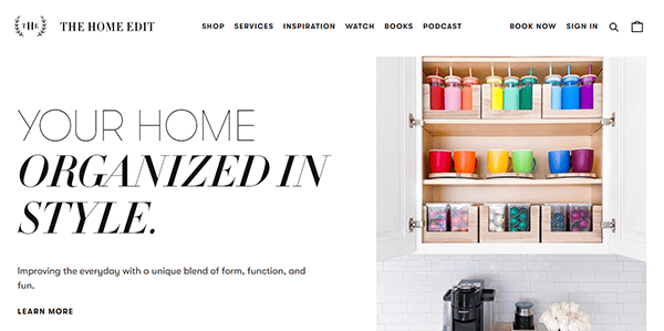 Website promoting home organization with a focus on style. Features an organized cabinet with colorful cups and neatly arranged items. Text reads, "Your home organized in style" with links to shop services and more.