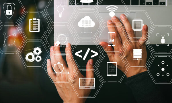 Hands typing on a laptop keyboard with overlay icons representing technology concepts such as security, coding, cloud storage, and data management—ideal for integrating medical practice management software.