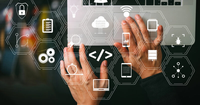 Hands typing on a laptop keyboard with overlay icons representing technology concepts such as security, coding, cloud storage, and data management—ideal for integrating medical practice management software.