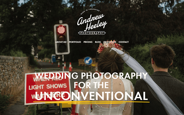 Bride and groom walking toward a road construction site with a banner that reads, "Wedding Photography for the Unconventional" and "Andrew Heeley Photography" logo above.