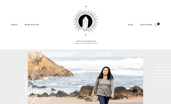 A woman is walking on a beach with rocks and waves in the background. The header of the website displays a logo, name, and navigation links, including "About," "Work With Me," "Blog," and "Disclaimer.