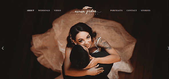 A bride with a visible tattoo on her arm and groom embrace, viewed from above. Website navigation options are displayed at the top of the image.