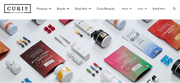 Various wellness products, including supplements, oils, and capsules, arranged on a white background. The branding "Curio Wellness" is visible on multiple packages.