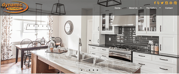 A modern kitchen with white cabinets, a black backsplash, and a marble island countertop. A dining area with a wooden table and chairs is visible in the background. The "Dynamic Kitchens" logo is in the top left corner.