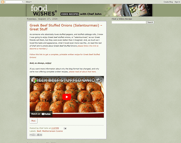 Screenshot of a blog post from "Food Wishes" featuring a recipe titled "Greek Beef Stuffed Onions (Salantourmasi)." The post includes an image of cooked stuffed onions and a video embedded below.