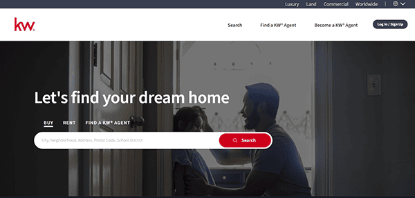 A man kneels in front of a child inside a dimly lit room. A search bar is displayed with options to buy, rent, or find an agent on the real estate website. Red and white "kw" logo is at the top left.