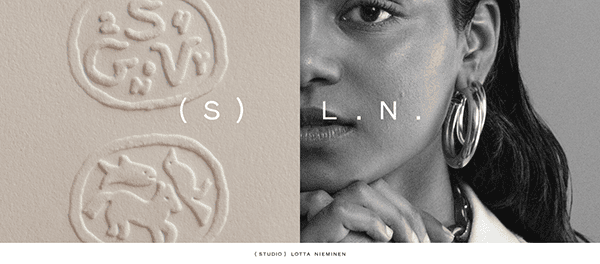 Close-up of a black and white photograph with clay stamps on the left and part of a woman's face on the right. Text "(S) L.N." is in the center. Below reads: "(STUDIO) LOTTA NIEMINEN.