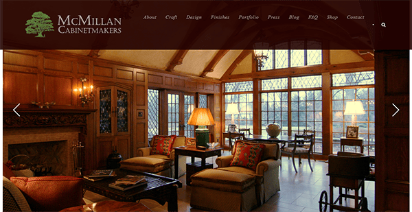 A cozy, wood-paneled living room with large windows, comfortable seating, and a warm ambiance, featuring the McMillan Cabinetmakers website header at the top portion of the image.