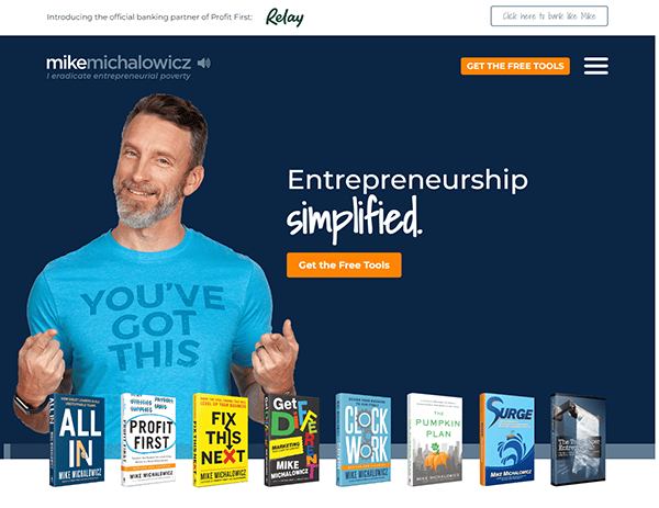 Man in a blue "You've Got This" T-shirt stands smiling with thumbs up in front of a dark blue background that reads "Entrepreneurship simplified." Several books are displayed at the bottom.