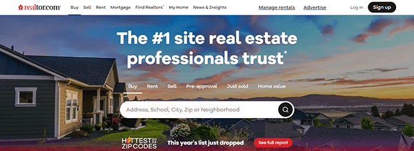 Homepage of realtor.com showing a search bar for real estate listings with options to buy, rent, sell, and more. Background features a scenic neighborhood with houses and a sunset view.