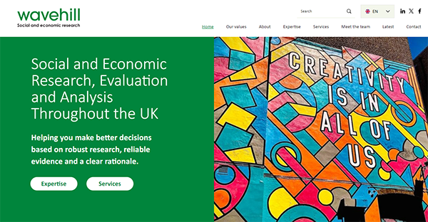 Wavehill homepage showcasing a vibrant graffiti mural. The text highlights their focus on social and economic research, evaluation, and analysis throughout the UK. Buttons for "Expertise" and "Services" are visible.