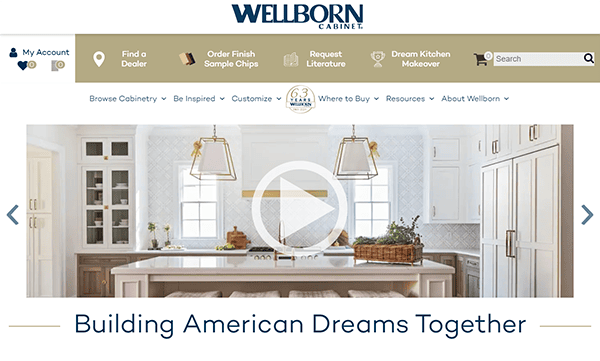 Website homepage of Wellborn Cabinet showing a modern kitchen with an island, pendant lights, and the slogan "Building American Dreams Together.