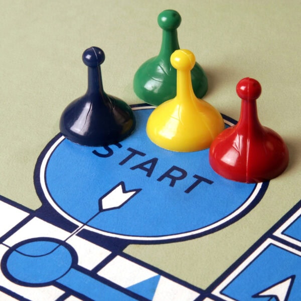 Four game pieces in blue, green, yellow, and red are positioned on a "START" space on a board game, ready to lead you on an exciting adventure. With rules as detailed as effective privacy policies and gameplay as strategic as mastering SEO, every move matters.