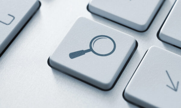 Close-up of a keyboard key with a magnifying glass icon, typically representing search functionality, often crucial when addressing Google search issues or fixing website visibility problems.