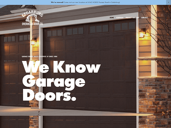 Exterior view of two dark brown garage doors with lantern lights on either side. Text on image reads: "We Know Garage Doors." Building is associated with Cedarburg Overhead Door Co, known for the best garage door solutions.