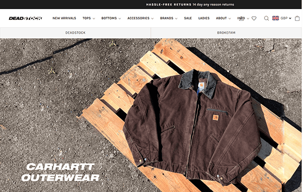 A brown Carhartt jacket with a black collar displayed on a wooden pallet outdoors, as featured on the Deadstock website's Carhartt Outerwear section.