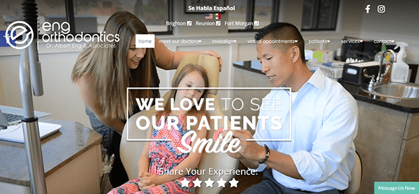 A dentist and a dental assistant examine a young girl in a dental clinic while an adult woman observes. The text overlay reads, “WE LOVE TO SEE OUR PATIENTS Smile.” The clinic’s name and social icons are visible.