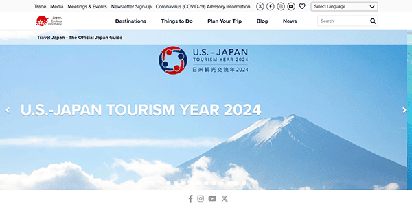 Website homepage featuring an announcement for "U.S.-Japan Tourism Year 2024" with an image of a snow-capped mountain under a blue sky.