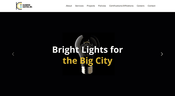 A webpage with a black background featuring an image of a light bulb and the text "Bright Lights for the Big City" in white and yellow. Navigation options are visible at the top.