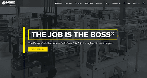 Screenshot of a company's website homepage. Text reads, "The Job is the Boss," with a tagline underneath about design-build services. Background shows industrial machinery. A yellow button says "View projects.