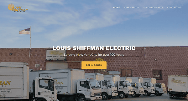 Image of the Louis Shiffman Electric homepage featuring their trucks lined up in front of a company building with the American flag waving above. Text overlay reads, "Serving New York City for over 100 years.