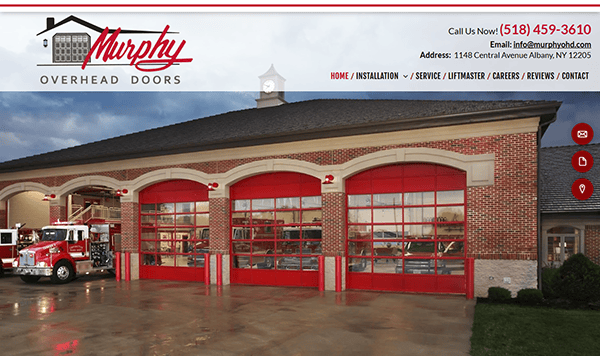 The exterior view of Murphy Overhead Doors showcases a striking red brick facade with three red garage doors, reflecting their acclaim for the best garage doors. A vibrant red truck is parked nearby, and contact information along with the address is prominently displayed at the top.