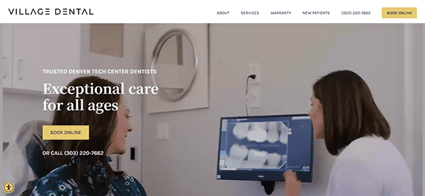 A dentist shows dental X-rays on a monitor to a patient in an exam room at Village Dental. The office offers services for patients of all ages and contact information is displayed on the screen.