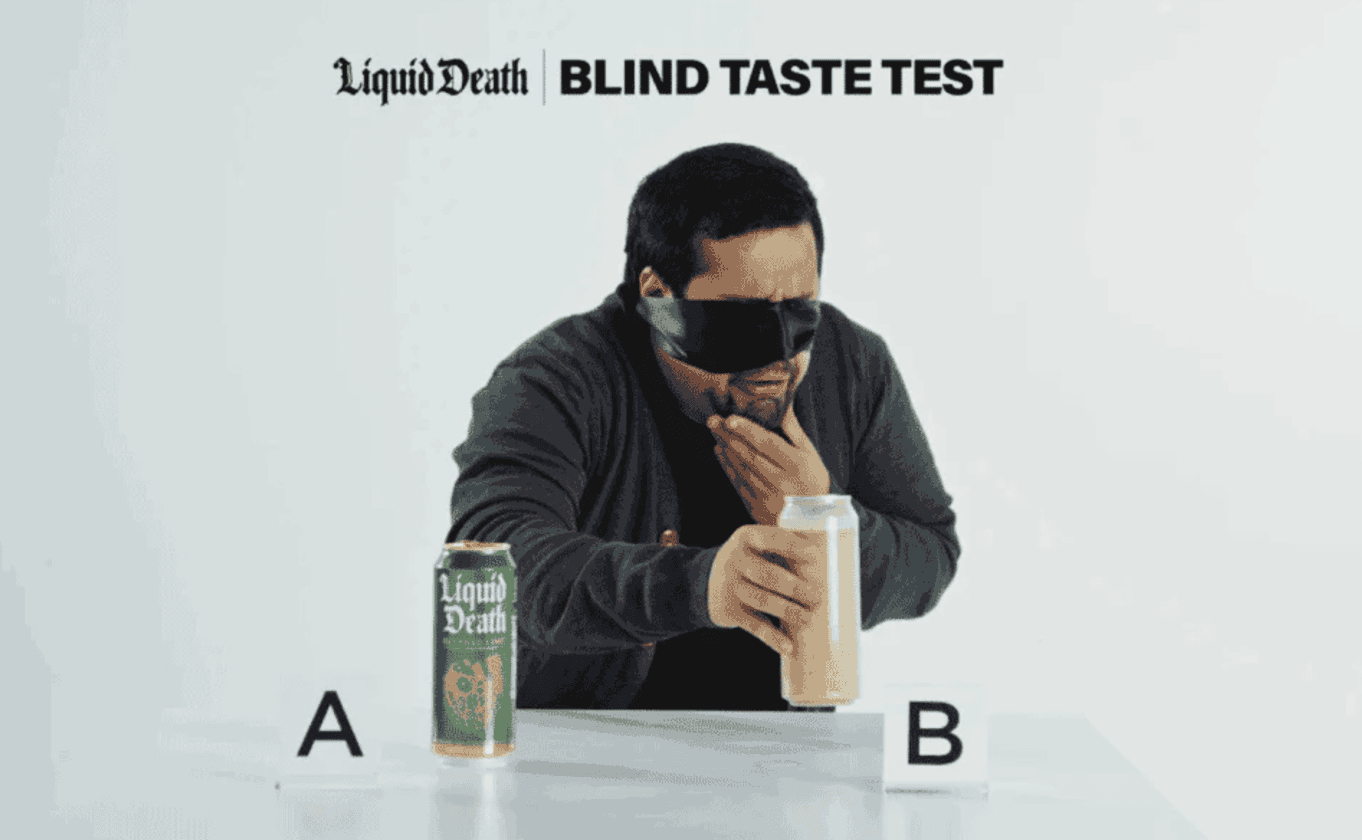 A man wearing glasses holds a can labeled "B" with "Liquid Death Blind Taste Test" text above, showcasing winning examples of captivating social media ads. Can "A" is placed on the table, setting the scene for a fun and engaging marketing experiment.