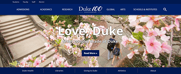 Cherry blossoms frame a view of Duke University's campus with the text "Love, Duke: Meet couples made at Duke," showcasing why it's featured on the best college websites for its captivating stories and campus beauty.