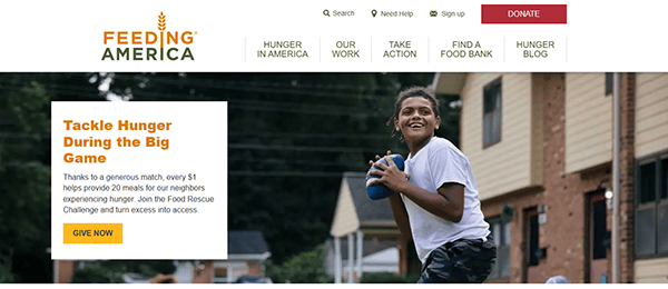 A boy plays with a football in a residential area, while the header and donation section of one of the top charity websites, Feeding America, are visible at the top.