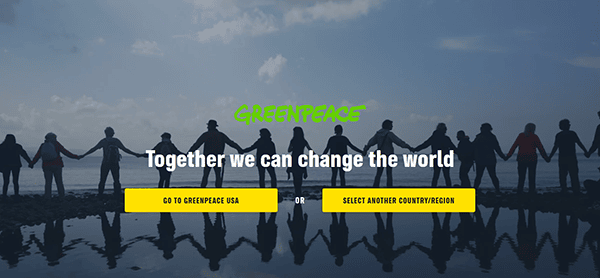 A group of people holding hands silhouetted against a blue sky with text saying, "Greenpeace: Together we can change the world." Explore one of the best charity websites with options below: "Go to Greenpeace USA" and "Select another country/region.